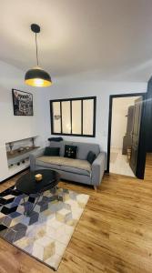salon z kanapą i stołem w obiekcie Cosy et jardin panoramique w mieście Morlaix
