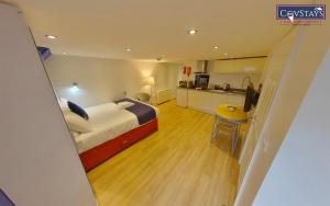 a hotel room with a bed and a kitchen at Cosy Escape - Studio Apartment in Coventry City Centre in Coventry