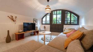 ein Wohnzimmer mit einem Sofa und einem TV in der Unterkunft Maison de Village - 291 in Duingt