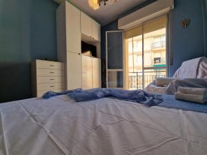 a large white bed in a room with a window at [P.ZZA MARCONI] Bilocale per la vacanza al mare in Pietra Ligure