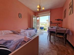 a bedroom with two beds and a table and a window at [P.ZZA MARCONI] Bilocale per la vacanza al mare in Pietra Ligure