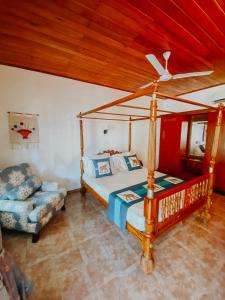 a bedroom with a canopy bed and a couch at Mother's Place Nimala in Hikkaduwa