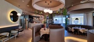 a restaurant with tables and chairs and a bar at Gotha Hotel Turin Airport in Ciriè
