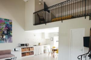 a living room with a staircase and a kitchen at Mas la Buissonniere in Aigaliers
