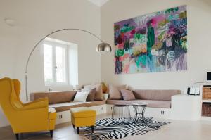 a living room with a couch and a painting at Mas la Buissonniere in Aigaliers