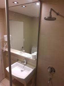 La salle de bains est pourvue d'un lavabo et d'un miroir. dans l'établissement Hotel Presidente, à Villa Carlos Paz