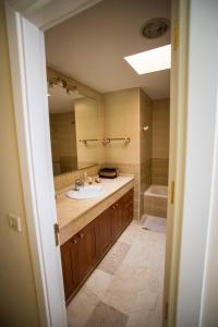 une salle de bain avec un lavabo et une baignoire dans l'établissement Orquídea Holiday Modern House, à Mogán