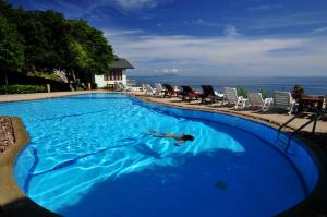 a person swimming in a large blue swimming pool at Phangan Utopia Resort in Mae Haad
