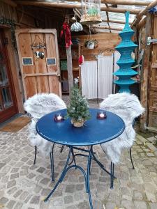 een blauwe tafel en stoelen met een kerstboom erop bij Gîtanneke in Burg-Reuland