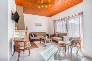 a living room with a couch and a table and chairs at Levanda Villas - Country villas with private pool in Exopoli