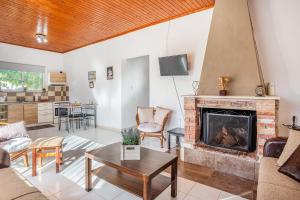 a living room with a fireplace and a table at Levanda Villas - Country villas with private pool in Exopoli