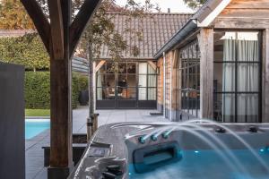 a house with a swimming pool next to a building at Sjiek Basiliek in Oudenbosch