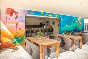a dining room with two tables and a mural at All Seasons Apartments in Kralendijk