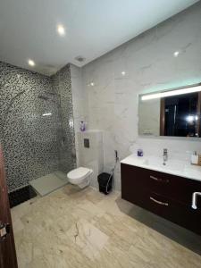 a bathroom with a toilet and a shower and a sink at Luxury spacious 3 Bed apt with pool in Agadir