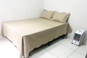 a small bed in a room with a scale at 202-FLAT-Espaço,conforto.È disso que você precisa! in Anápolis