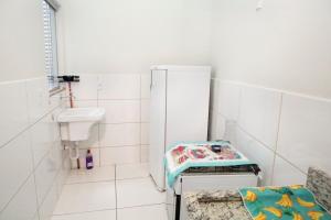 a small bathroom with a sink and a refrigerator at 203-FLAT-Espaço,conforto.È disso que você precisa! in Anápolis