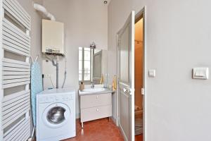 een badkamer met een wasmachine en een wastafel bij Le Vieux Sextier - AC Clim - Lumineux - WIFI - Hypercentre in Avignon
