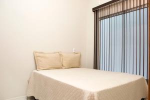 um quarto com uma cama e uma grande janela em 204-FLAT-Espaço,conforto.È disso que você precisa! em Anápolis