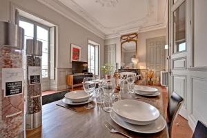 una sala da pranzo con tavolo, piatti e bicchieri da vino di Le Vieux Sextier - AC Clim - Lumineux - WIFI - Hypercentre ad Avignone