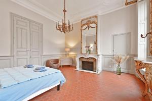 a bedroom with a bed and a fireplace and a mirror at Le Vieux Sextier - AC Clim - Lumineux - WIFI - Hypercentre in Avignon