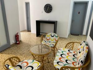 a living room with chairs and a table and a fireplace at Sunset view Rooms in Agia Triada