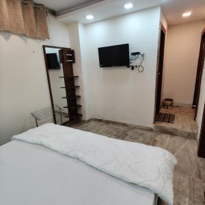Schlafzimmer mit einem Bett und einem Flachbild-TV in der Unterkunft Hotel Shreeji Residency in Pachmarhi