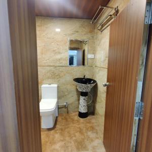 łazienka z toaletą i umywalką w obiekcie Hotel Shreeji Residency w mieście Pachmarhi