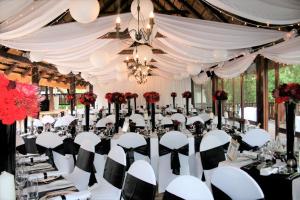 uma configuração para uma recepção de casamento numa tenda com mesas e cadeiras em Premier Hotel Roodevalley em Pretoria