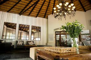 a living room with a table and a chandelier at Premier Hotel Roodevalley in Pretoria