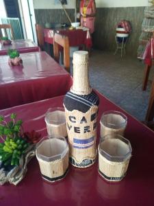 a vase sitting on a table with four cups at Pam de Terra 