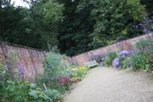 a garden with a bench next to a brick wall at Lydiard Park Hotel in Swindon