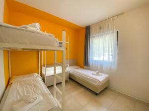 two bunk beds in a room with a window at Belvedere Village in Castelnuovo del Garda