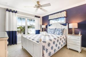 una camera con letto bianco e pareti blu di LaMedeira 305 Unit A a Holmes Beach Altre 27 foto