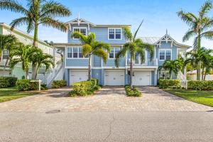 una casa blu con palme di fronte di LaMedeira 305 Unit A a Holmes Beach