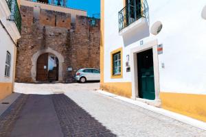 un callejón frente a un castillo con un coche en Casa de Viana do Alentejo, en Viana do Alentejo