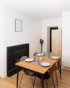 a dining room with a table with chairs and a fireplace at LA SUITE SEPT LE BRAS DOR in Boulogne-sur-Mer