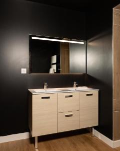 La salle de bains est pourvue d'un lavabo et d'un miroir. dans l'établissement LA SUITE SEPT LE BRAS DOR, à Boulogne-sur-Mer
