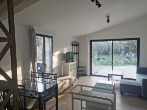 un soggiorno con divano e tavolo in vetro di Maison indépendante avec piscine, 10min Avignon a Pujaut