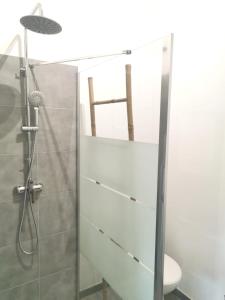 uma casa de banho com uma cabina de duche em vidro, um WC e um banco. em Maison indépendante avec piscine, 10min Avignon em Pujaut