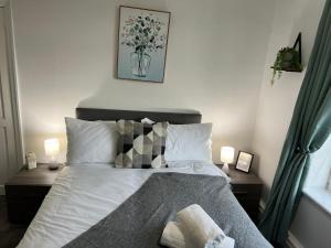 a bedroom with a bed with two nightstands and two lamps at Honeybee House in Redcar