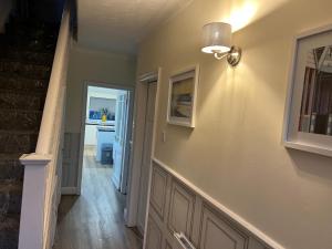 a hallway of a home with a staircase and a light fixture at Honeybee House in Redcar