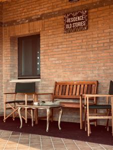 a bench and a table next to a brick wall at RESIDENCE OLD STORIES in Barile