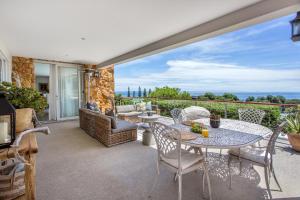 a patio with a table and chairs and a view of the ocean at Far Horizons Camps Bay in Cape Town