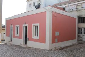 um edifício vermelho e branco numa rua em Terreirinho 1 e 2 em Sacavém