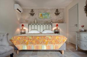 ein Schlafzimmer mit einem Bett, zwei Lampen und einem Stuhl in der Unterkunft Aux Augustins Palais des Papes & Wellness in Avignon