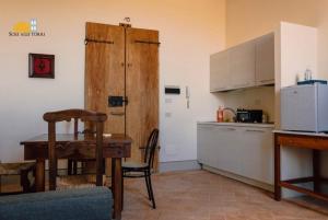 uma cozinha com uma mesa e um armário de madeira em Appartamenti Sole alle Torri em Assis