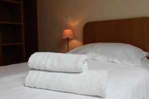 2 handdoeken worden op een bed gestapeld bij La Bullote - Gîtes - Paris Roissy in Villeneuve-sous-Dammartin