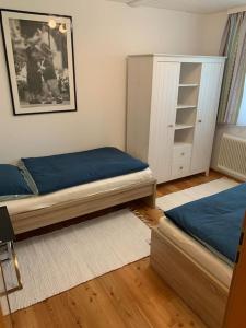 um quarto com 2 camas individuais e um armário em Appartement Centerbase Salzburgerland em Sankt Veit im Pongau