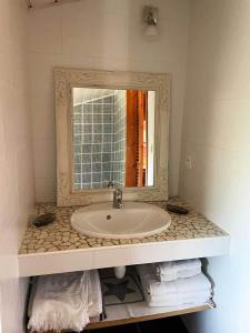 La salle de bains est pourvue d'un lavabo et d'un miroir. dans l'établissement Yamina Lodge, à Cap-Ferret