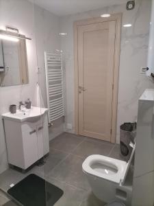 uma casa de banho branca com um WC e um lavatório em Apartman Mima em Sombor
